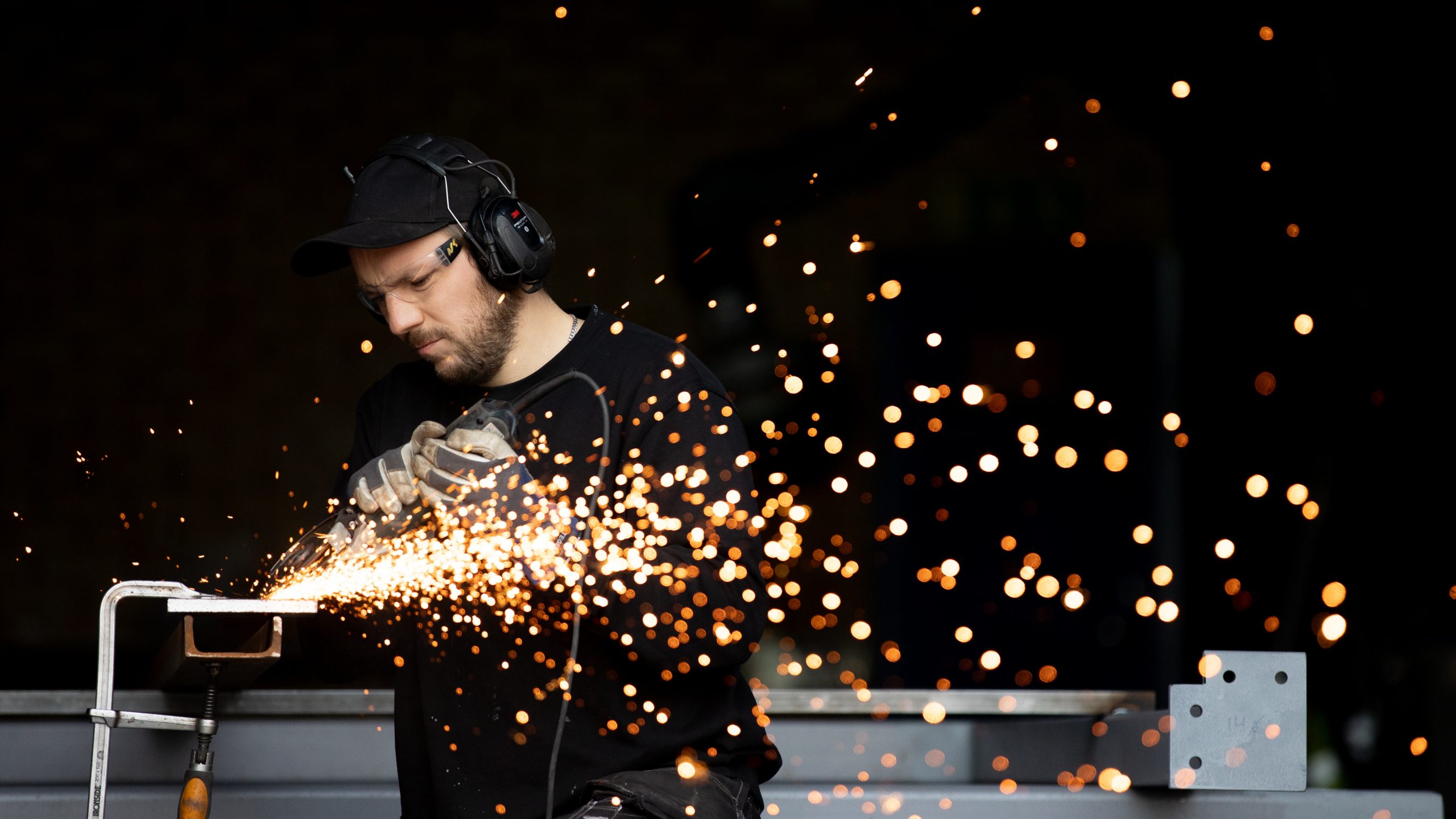 En erfaren smed i arbete – svetsar för att ge styrka och långvarig kvalitet åt byggnationer.